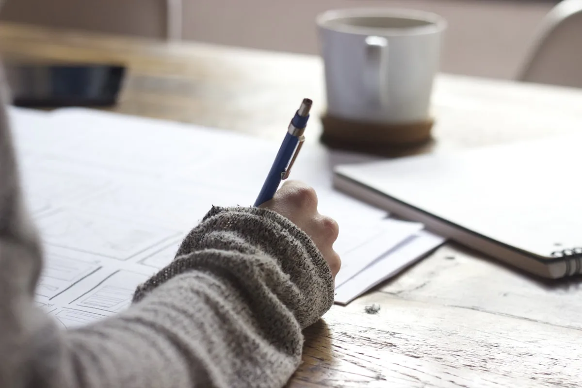 Overwhelmed person at desk with paperwork